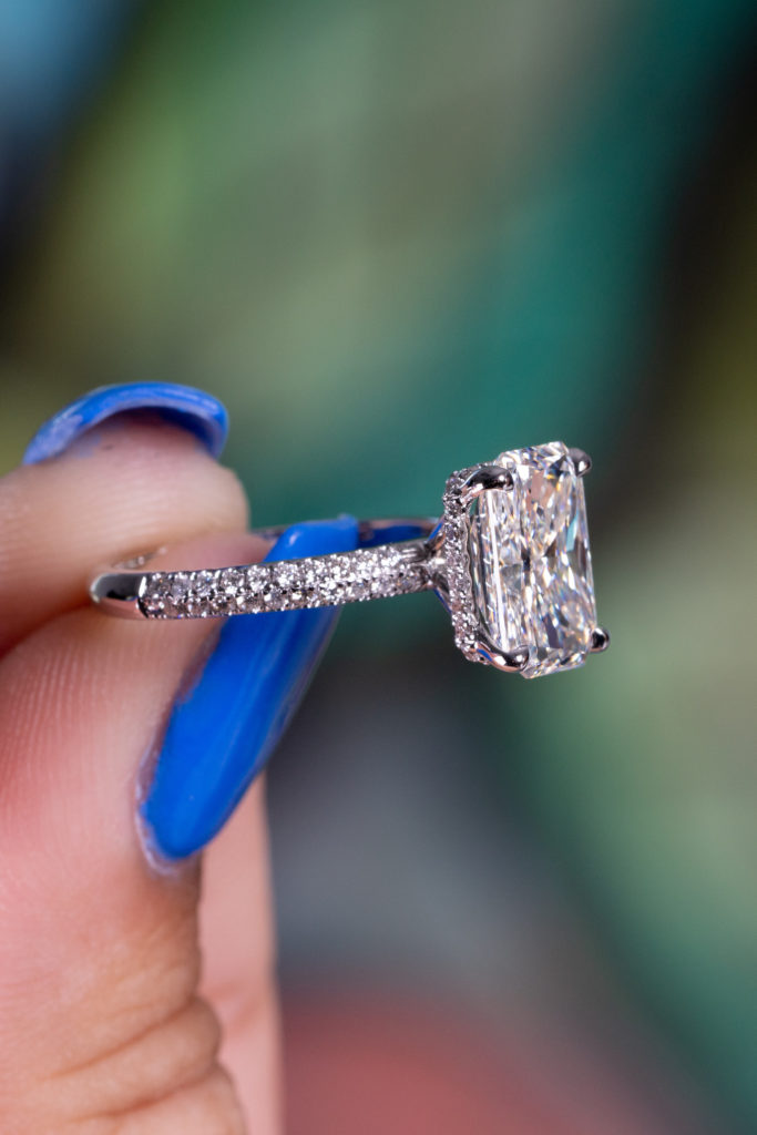 a colorless cushion cut diamond in a ring with accents