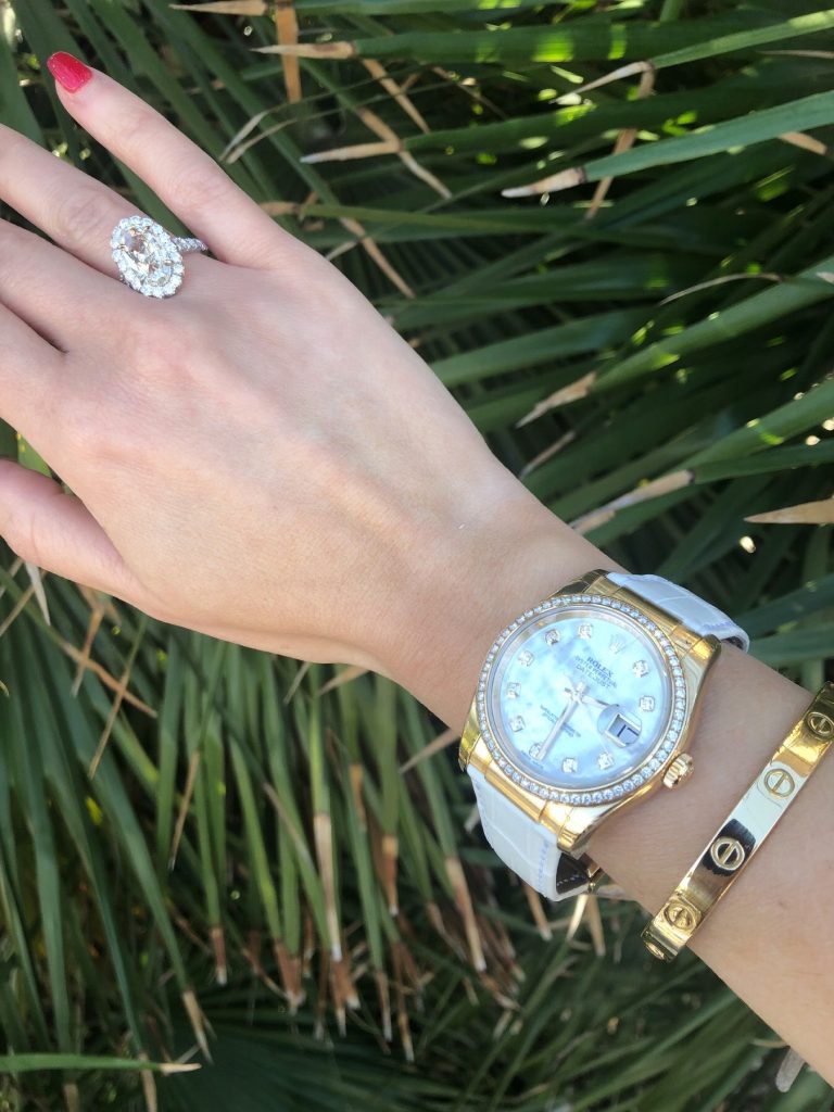 rolex datejust diamond and mother of pearl worn with cartier love bracelet bangle and halo engagement ring at local watch store