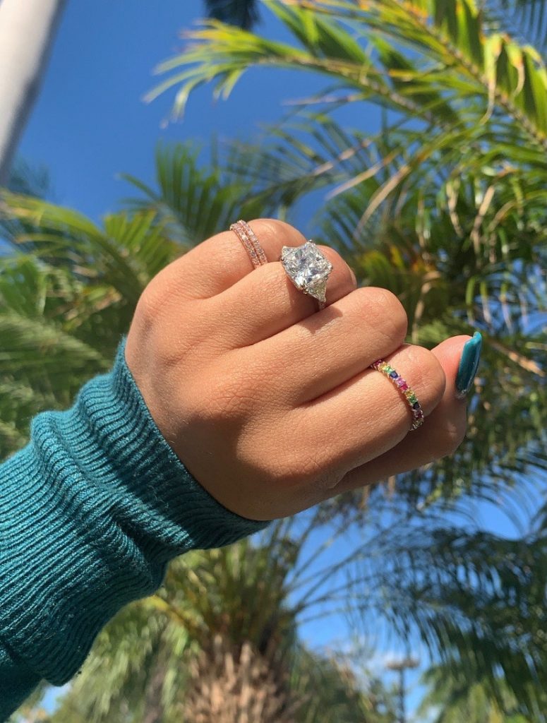 Princess cut diamond princess engagement ring worn with colorful gemstone bands